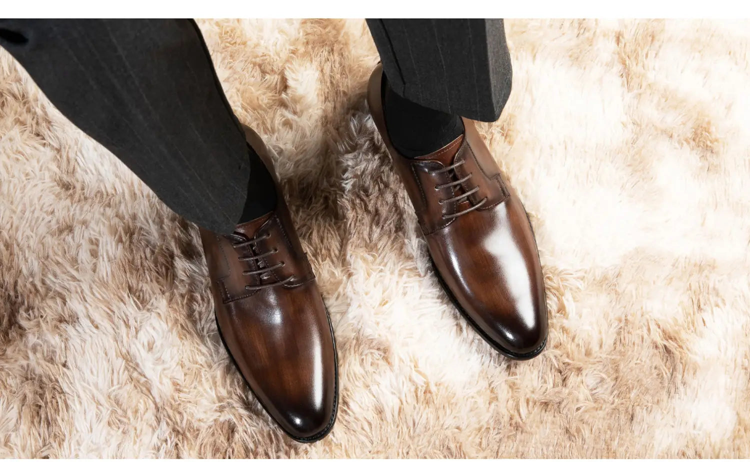 Herren-Oxfords aus handgeriebenem Leder in poliertem Braun mit klassischem Schnürdesign und spitzen Zehen.