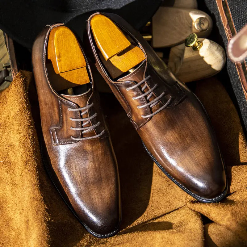 Polierte braune Herren-Oxfords aus handgeriebenem Leder mit klassischem Design und Einlagen in Hellbraun.