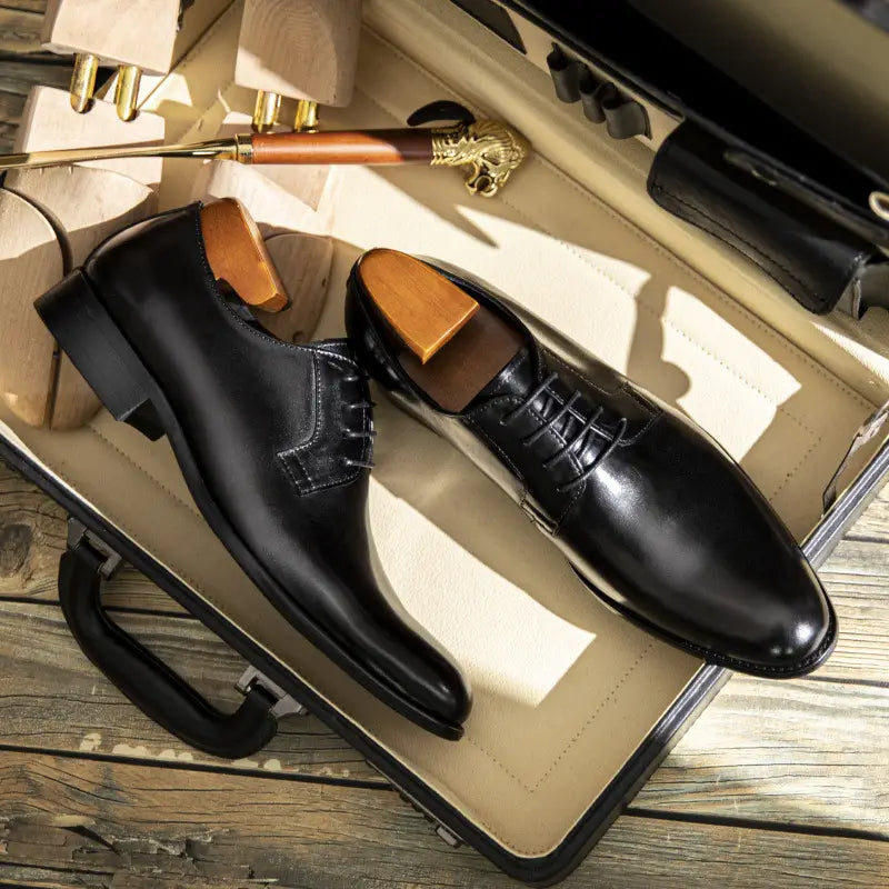 Herren-Oxfords aus handgeriebenem Leder in Schwarz mit polierter Oberfläche und Einlagen aus Holz.