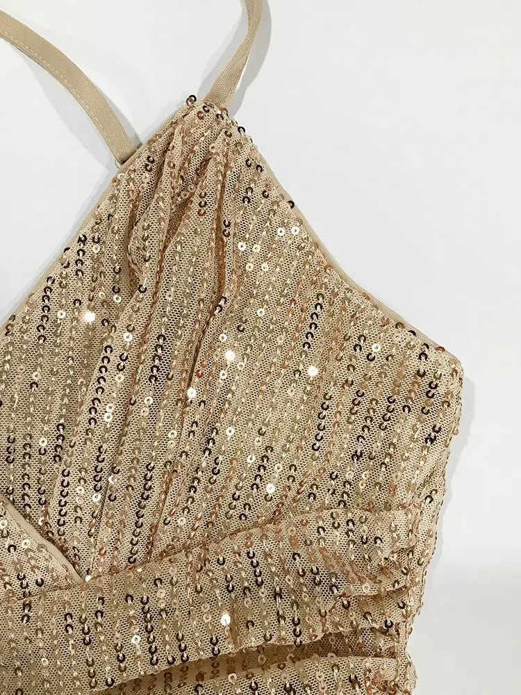 Un haut porte-jarretelles à sequins dorés scintillants avec un détail froncé délicat et des bretelles fines, présenté comme une robe de vacances à bretelles croisées en sequins.