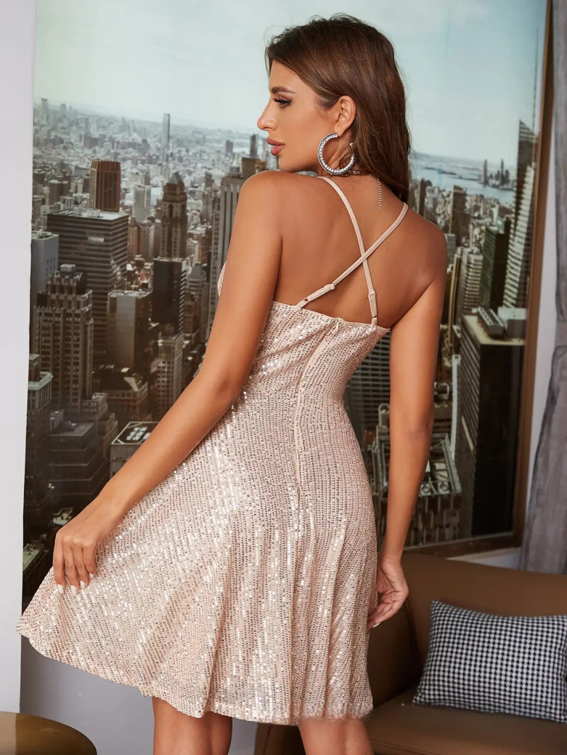 Une robe de vacances mini en sequins dorés rose scintillants avec un design de bretelle croisée flatteur, présentée de dos.