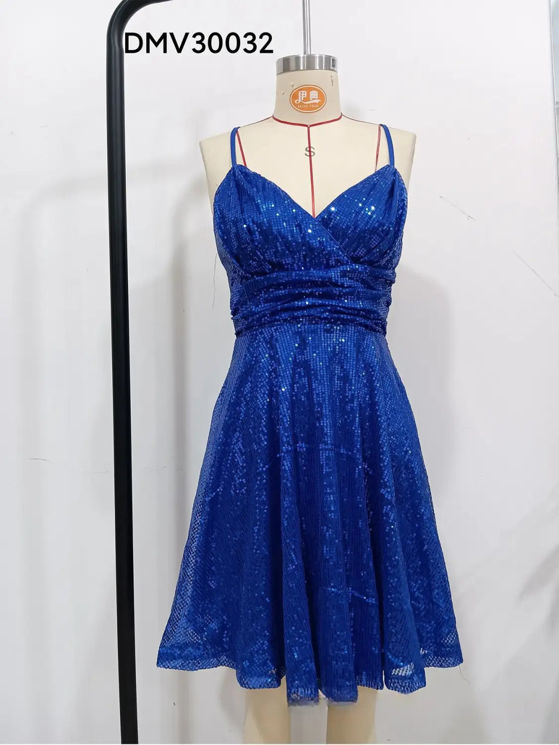 Une mini-robe bleue royale scintillante en sequins, avec un décolleté cœur et une taille froncée, présentée sur un mannequin pour les tenues de vacances.