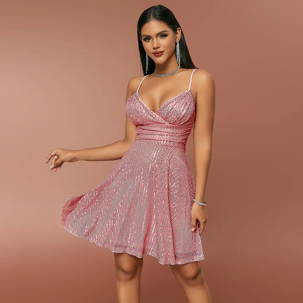 Une mini-robe rose scintillante en sequins, avec de fines bretelles spaghetti et un décolleté en V flatteur, conçue comme une robe de vacances à bretelles croisées en sequins.