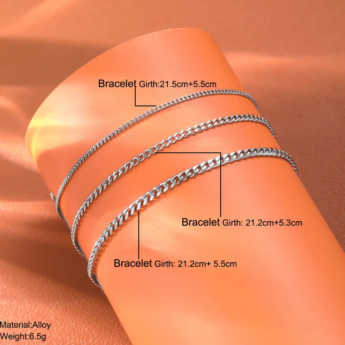 Three silver-toned chain bracelets with a sleek interlocking design in a unisex silver layered Cuban and Figaro link bracelet set.