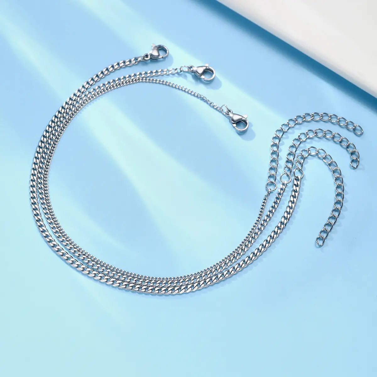 Unisex silver layered Cuban and Figaro link bracelet set featuring a silver-toned chain strap with a textured interlocking link design and multiple adjustable clasp ends.