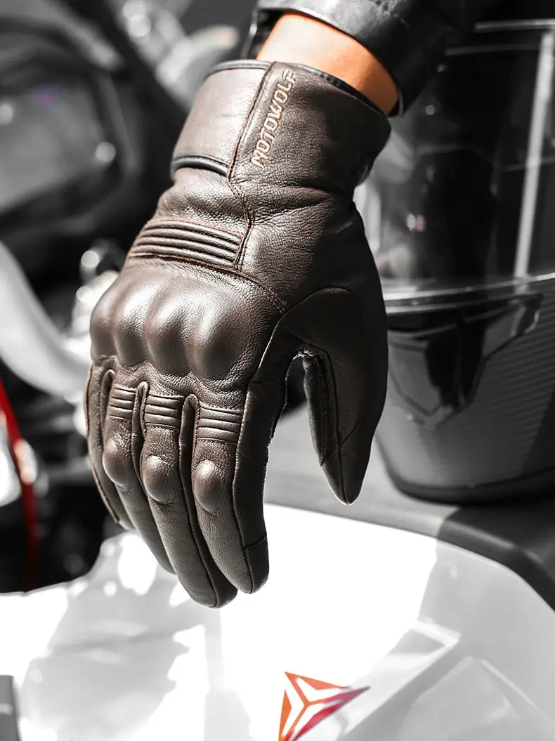 Back side of black leather men winter motorcycle glove with reinforced knuckle padding and motowolf brand logo on the wrist strap.