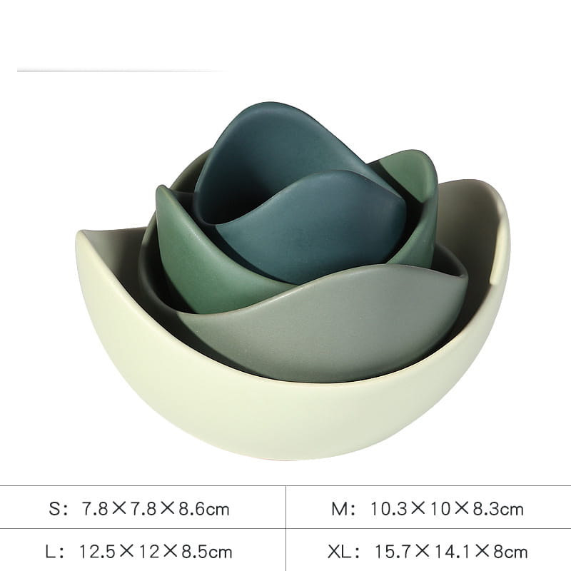 Set of four nested ceramic lotus bowls in pastel pink with a soft matte finish and layered greenish-blue hues resembling an open flower.