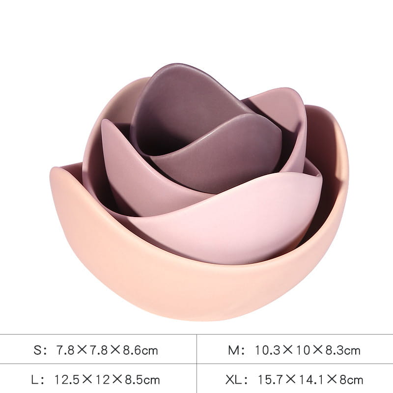 Set of four pastel pink and mauve ceramic nesting bowls shaped like a lotus flower for decorative serving.