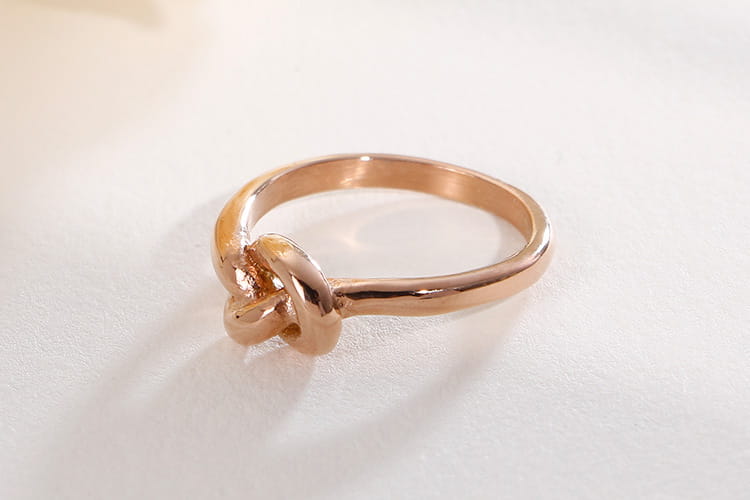 Rose gold geometric Truelove knot titanium steel ring with a smooth polished band and intricate tied design.