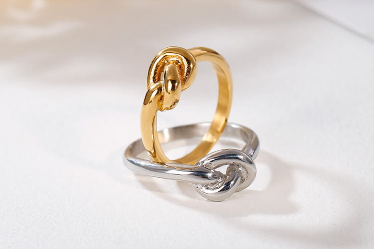 Gold and silver geometric truelove knot titanium steel rings with a polished metallic finish.