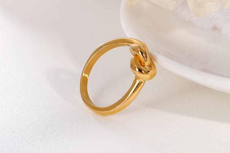 Geometric truelove knot titanium steel ring in gold color with a sleek polished metallic finish.