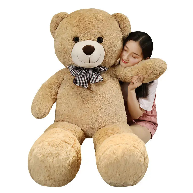 Ein flauschiger Teddybär aus hellem Braun als Plüschtier mit weißem Schnäuzchen, schwarzen Knopfaugen und einer karierter Fliege.