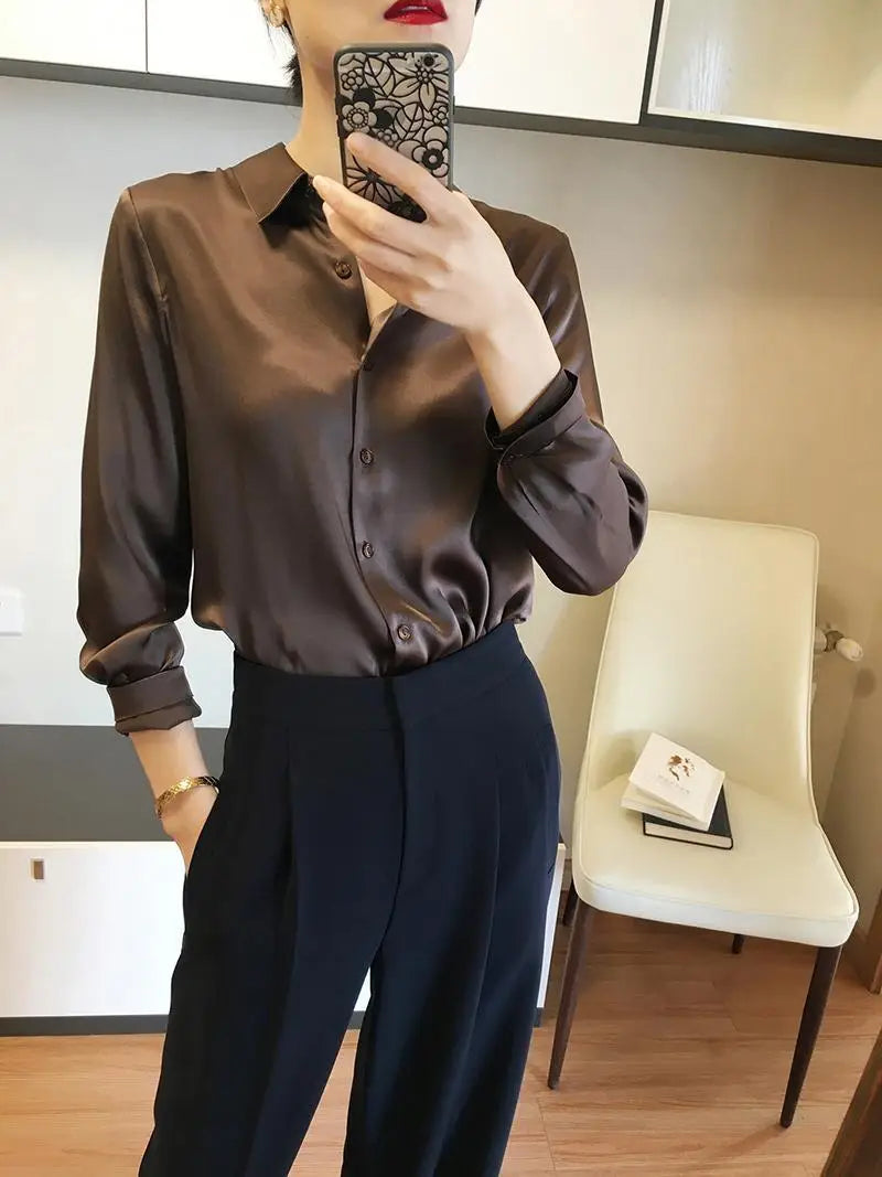 A sleek long sleeve brown satin blouse with a classic collar and button down front made of silk.