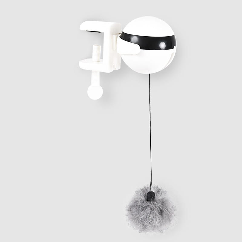 Jouet interactif pour chat à bille teaser à levage automatique, doté d’un corps sphérique blanc avec une bande noire et d’un pompon gris duveteux suspendu à une corde, monté sur une pince murale.
