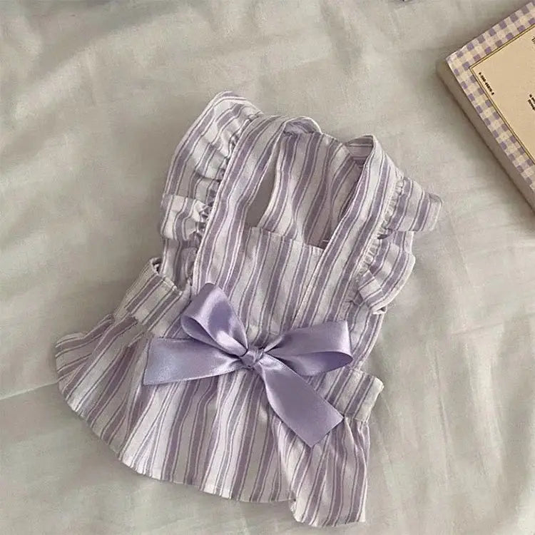 Un gilet pour animal de compagnie délicat rayé lavande et blanc, à bords volantés et à un nœud en satin assorti au centre, issu de la collection de la robe pour chien de princesse rayée avec nœud.