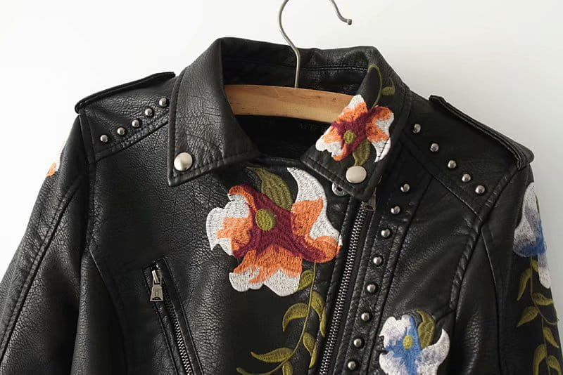 Black leather biker jacket with colorful embroidered floral patches and silver studs along the collar and zipper line called floral embroidered studded leather moto jacket.
