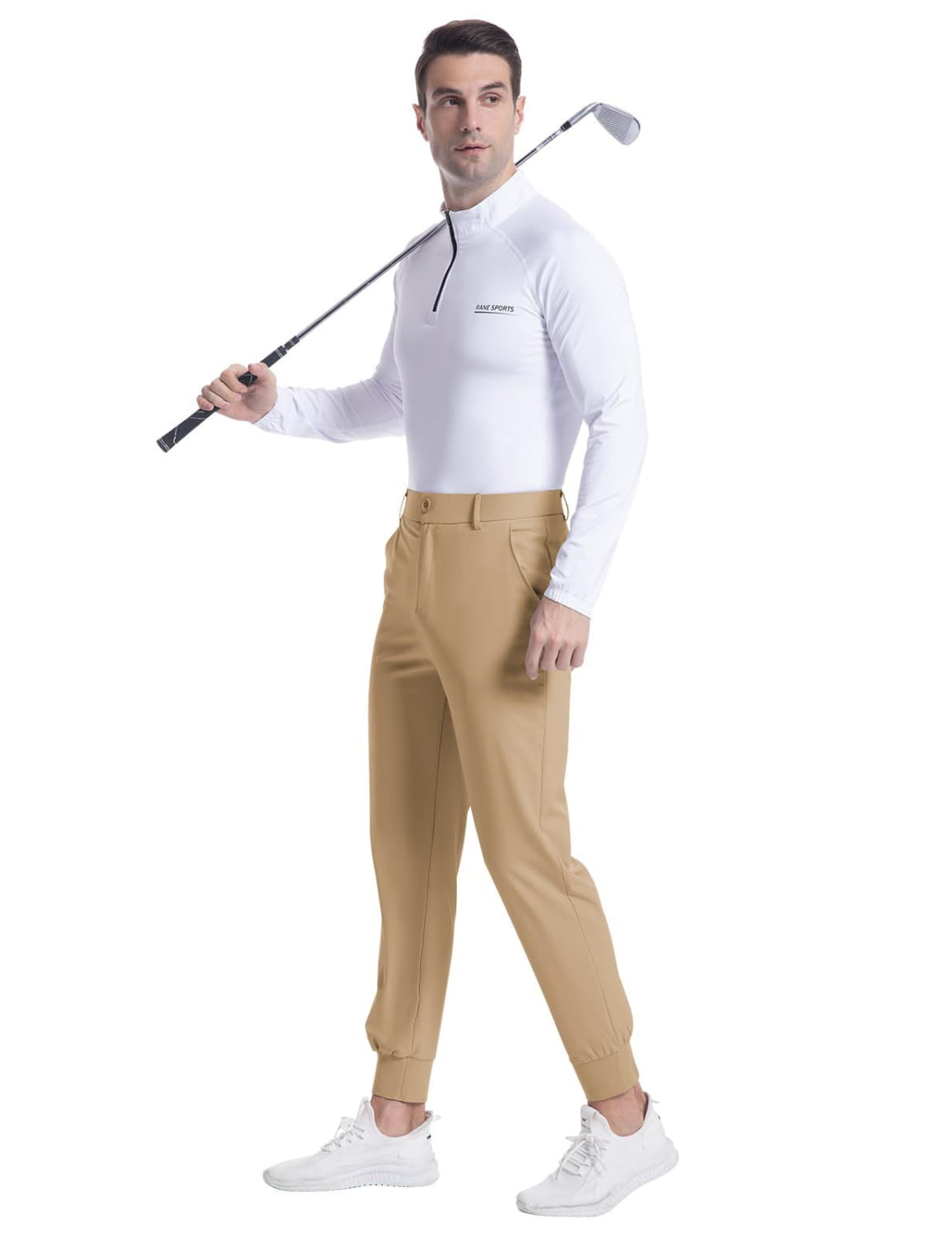 A man wearing beige slim fit men’s stretch golf jogger pants paired with a white long-sleeved golf shirt.