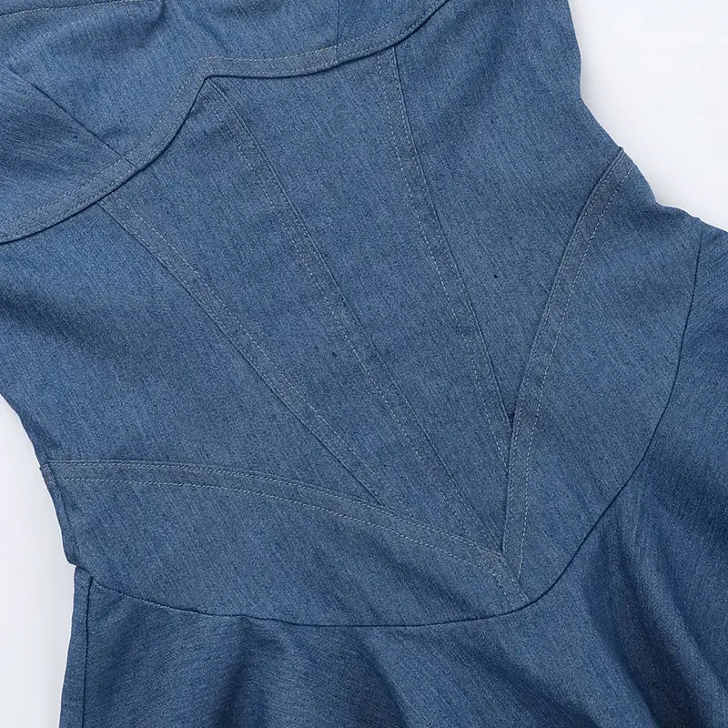 Vestido mini azul de denim entallado que presenta un corpiño tipo corsé estructurado con escote corazón y detalles de costuras visibles.