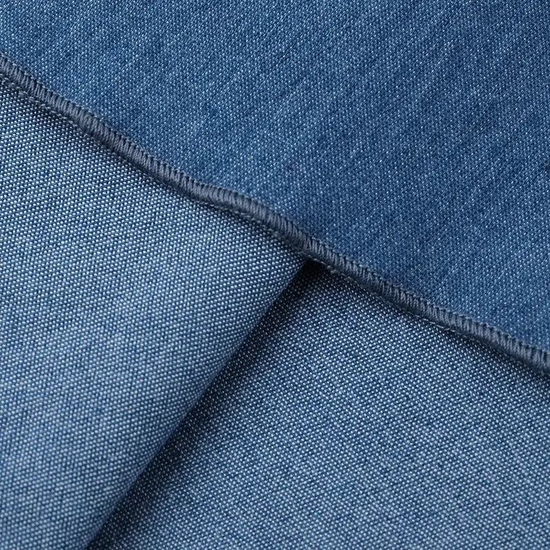 Tela de denim azul con tejido en relieve y costuras cosidas con precisión en un vestido mini tipo corsé de escote corazón en denim.