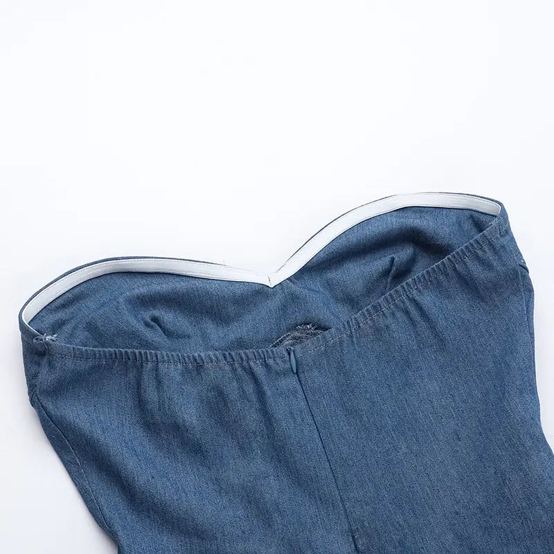 Vestido mini de corsé sin tirantes de denim azul con escote corazón y ribete blanco a lo largo del escote.