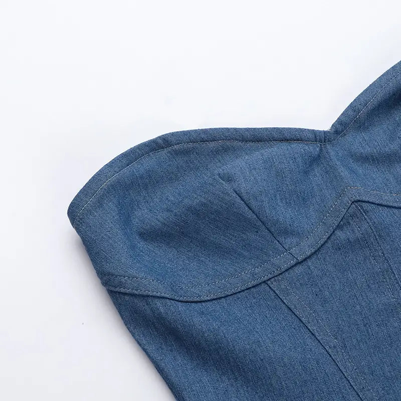 Tela de denim azul con costuras visibles y una costura de hombro estructurada en un vestido mini tipo corsé de denim de escote corazón