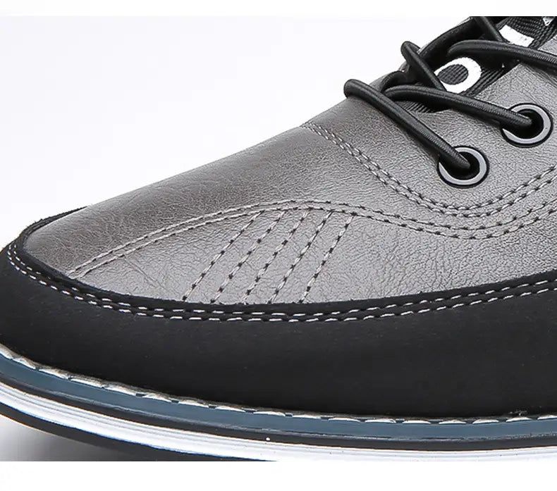Chaussure de sport imperméable pour homme en cuir véritable gris, avec lacets noirs et détail de couture blanche le long de la semelle.