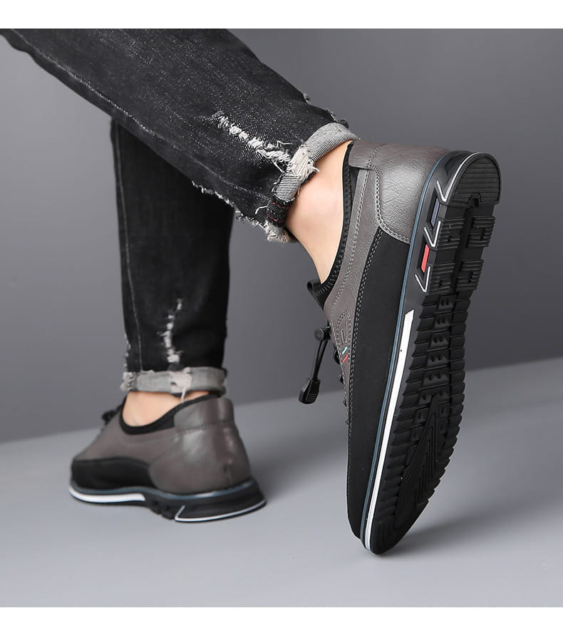 Chaussure de sport imperméable pour homme en cuir véritable gris et noir, avec dessus texturé, bande de semelle intermédiaire blanche et accent latéral rouge.