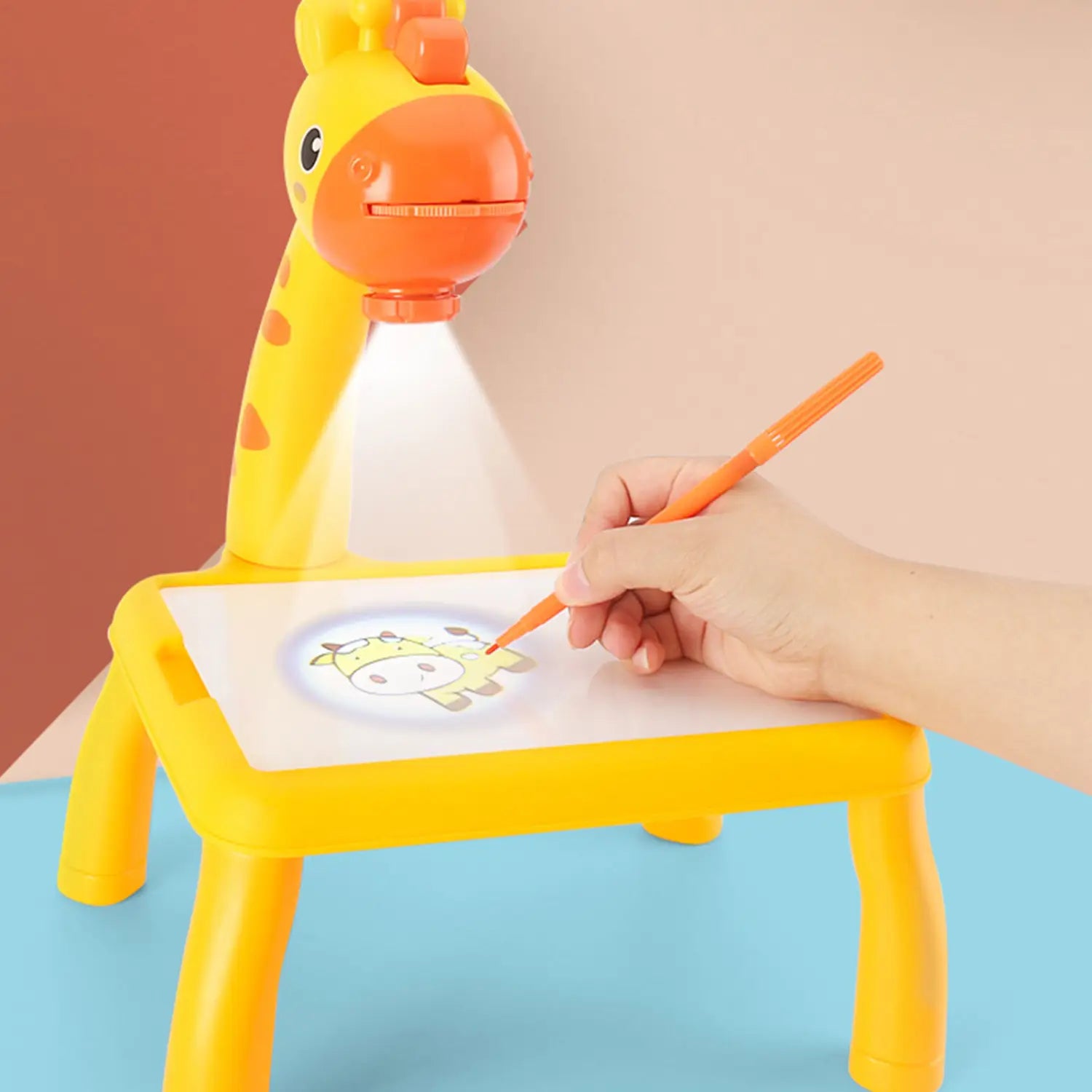 Yellow giraffe-shaped LED drawing projector table for kids art painting with orange accents and built-in light beam projecting a cartoon image onto paper.