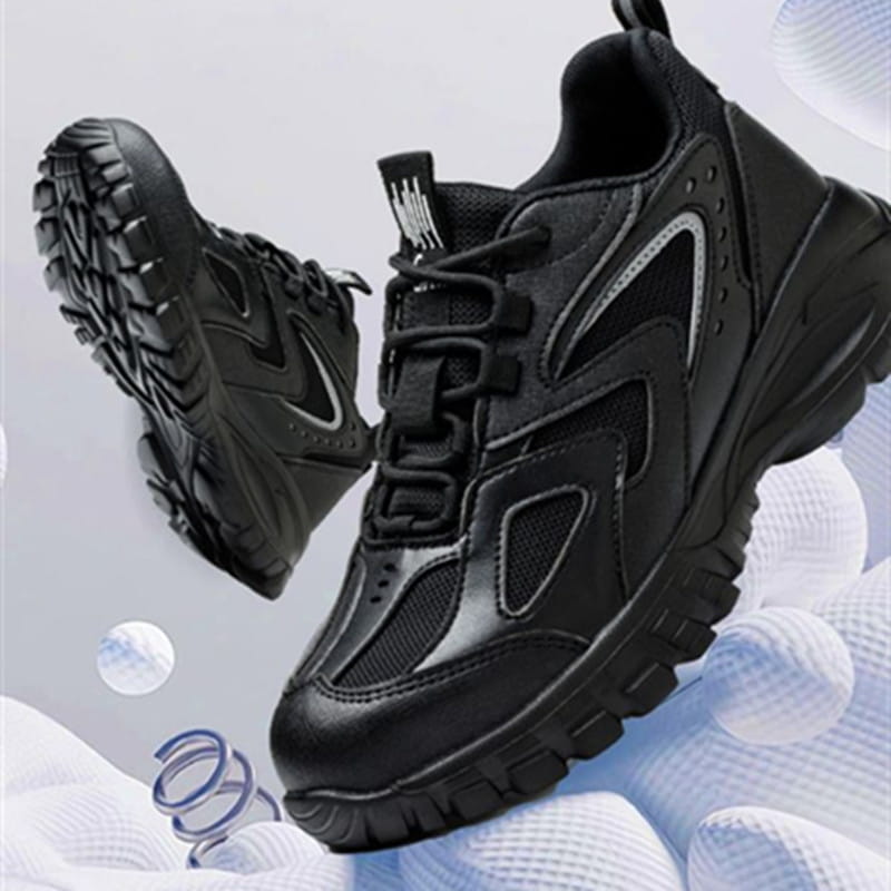 Men’s indestructible mesh athletic safety shoes in black with a matte finish, featuring chunky design, mesh panels, and subtle silver accents along the sides.