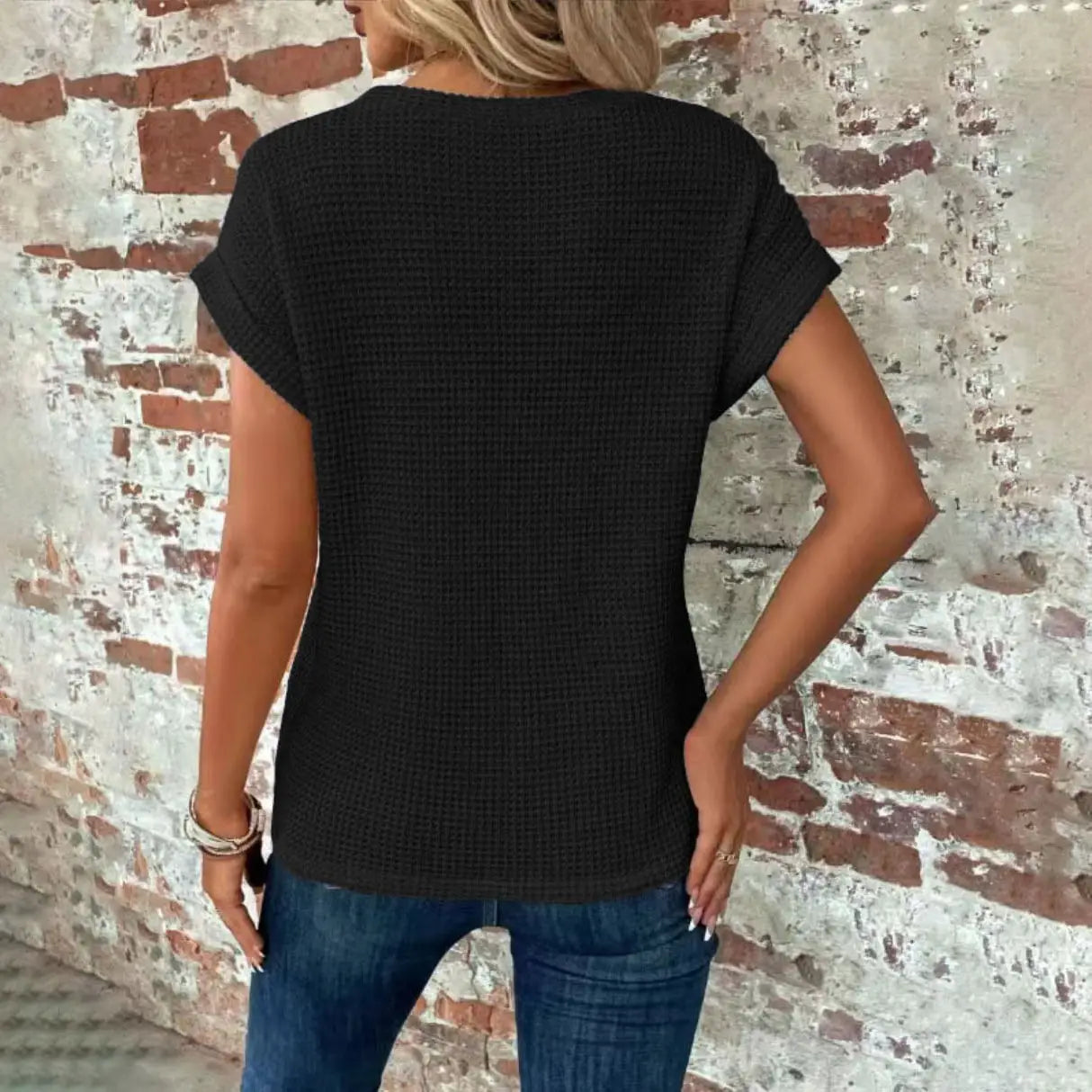 Black waffle-knit short-sleeved top for women with a relaxed fit and textured fabric.