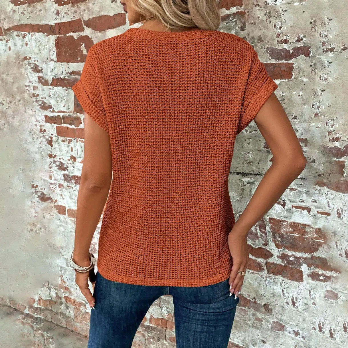 A rust-orange waffle knit short sleeve top for women featuring a relaxed fit.