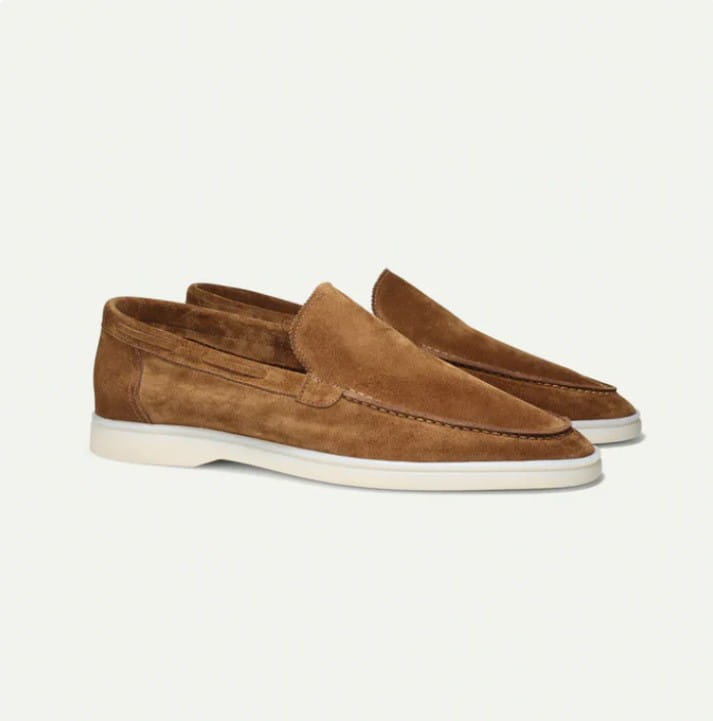 Men’s matte tan suede slip-on loafers with a white rubber sole and casual design.