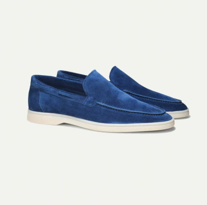 Men’s royal blue matte suede slip on loafers with a white rubber sole.