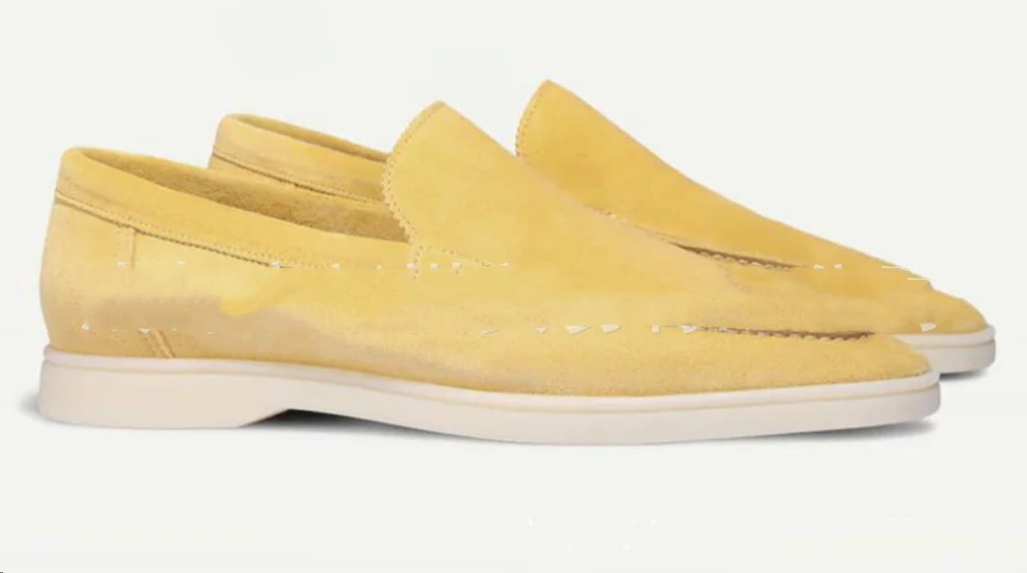 Pair of men’s pale yellow matte suede slip on loafers with white rubber soles.