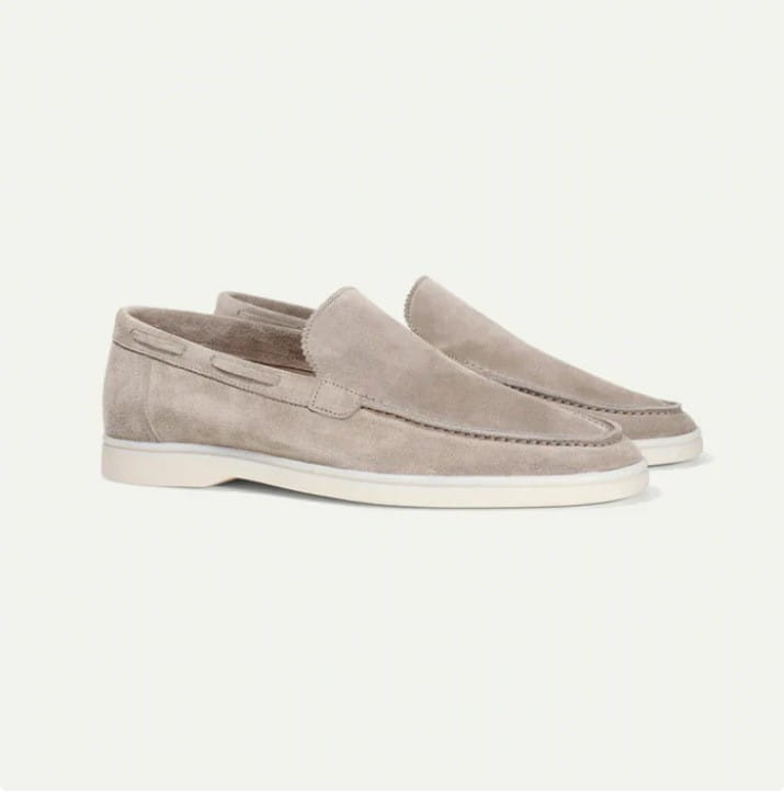 Beige suede men’s slip on loafers with white rubber sole and classic moccasin stitching.