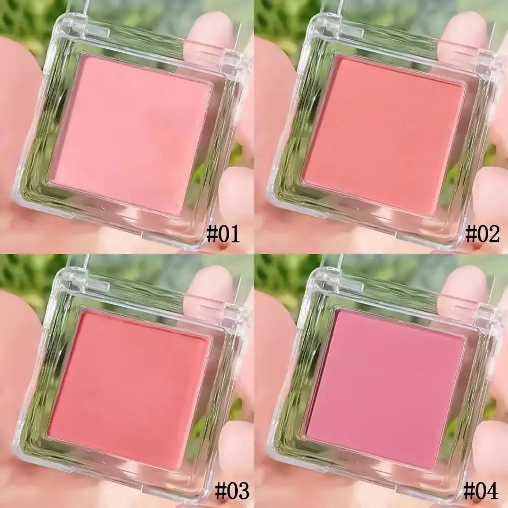 Clear plastic square compact containing four shades of pink monochrome powder blush with brush for versatile makeup application.