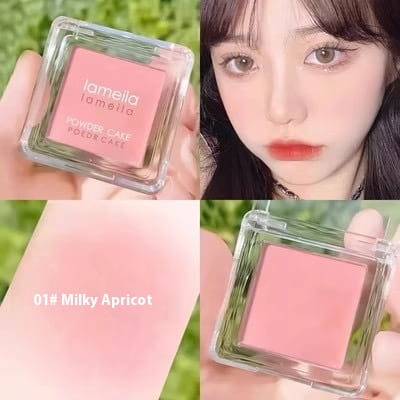 Lamella monochrome powder blush compact with brush in shade milky apricot with a soft pink hue displayed in a clear square powder cake blush compact.