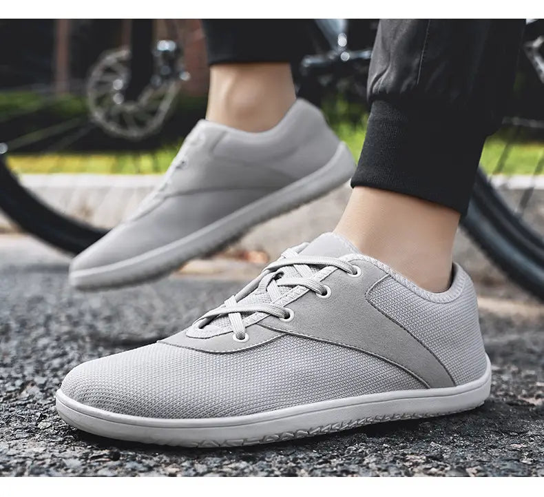 men’s wide toe breathable mesh running sneakers in gray with white laces and a white rubber sole.
