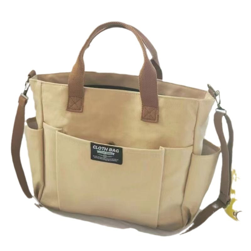 Beige large capacity canvas commuter tote with brown leather handles and shoulder strap.