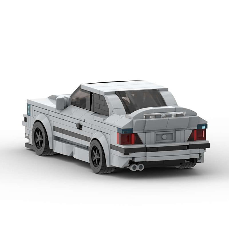 Modèle de voiture de sport E36 construit en Lego gris, avec roues noires et feux arrière rouges, présenté depuis le côté arrière, composé de 509 pièces, jouet.