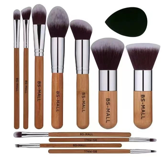 Set aus 11 Make-up-Pinseln mit Bambusgriff, silbernen Zwingen und dunkelbraunen bis grauen Farbverlaufborsten, ergänzt durch einen schwarzen Beauty-Blender aus Silikon in einem Bambus-Make-up-Pinselset mit Schwamm.