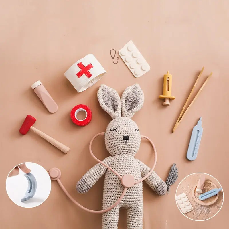 Juguete conejo tejido a crochet color beige con los ojos cerrados y usando un estetoscopio, forma parte del set de juguete médico infantil de doctor de madera y silicona.