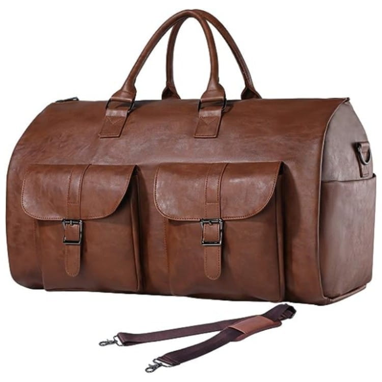 Brown leather multifunctional canvas and leather folding travel duffel bag with two front flap pockets secured by metal buckles and a detachable shoulder strap.