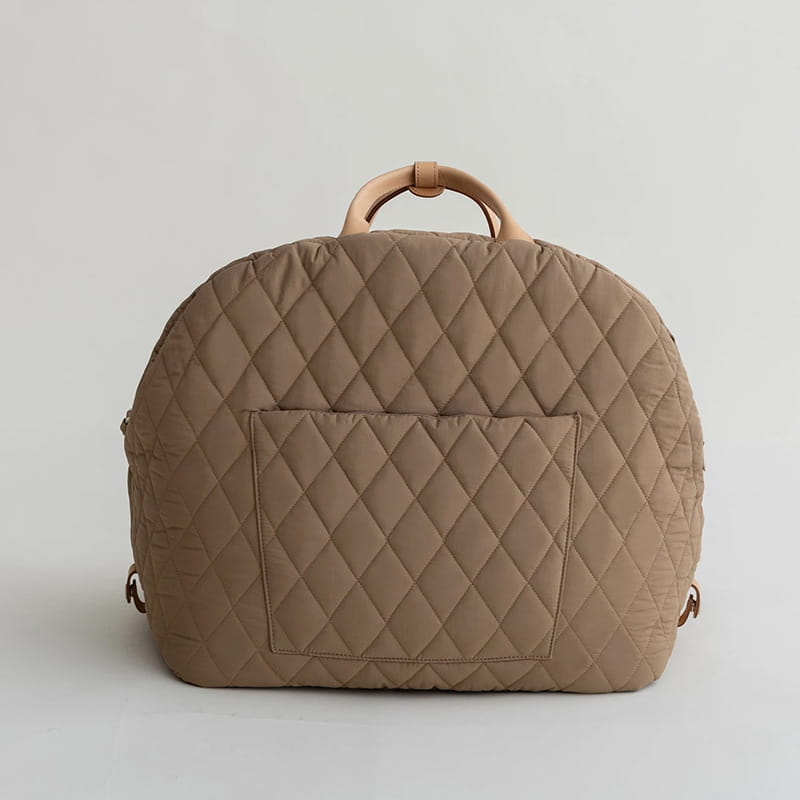 Beige quilted travel pet carrier bag with diamond-stitched pattern and tan leather handles shown from the back side.