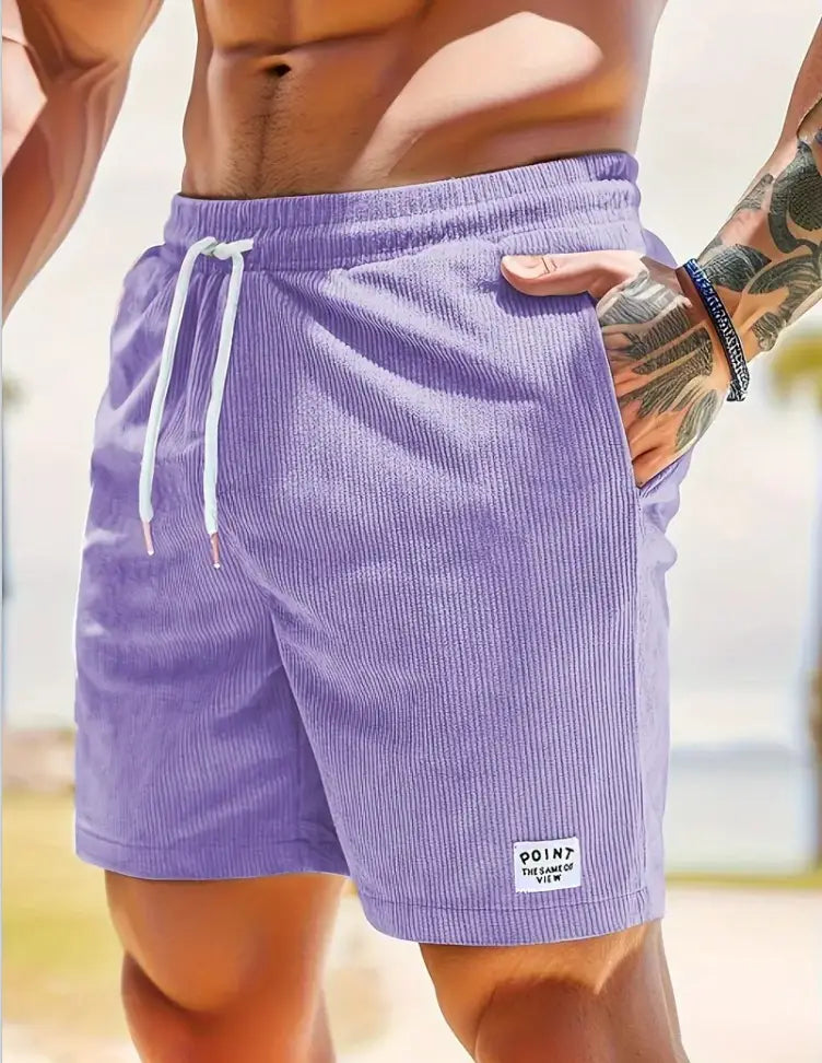 Shorts en velours côtelé violet à cordon de serrage pour hommes, avec des cordons de serrage blancs et une petite étiquette « point de vue » sur la partie inférieure droite de la jambe, conçus pour les vêtements de sport.