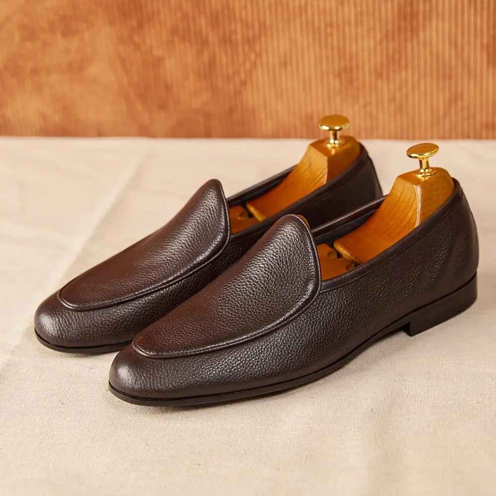 Brown textured cowhide leather loafers with a pebbled design and classic slip-on pointed toe style.