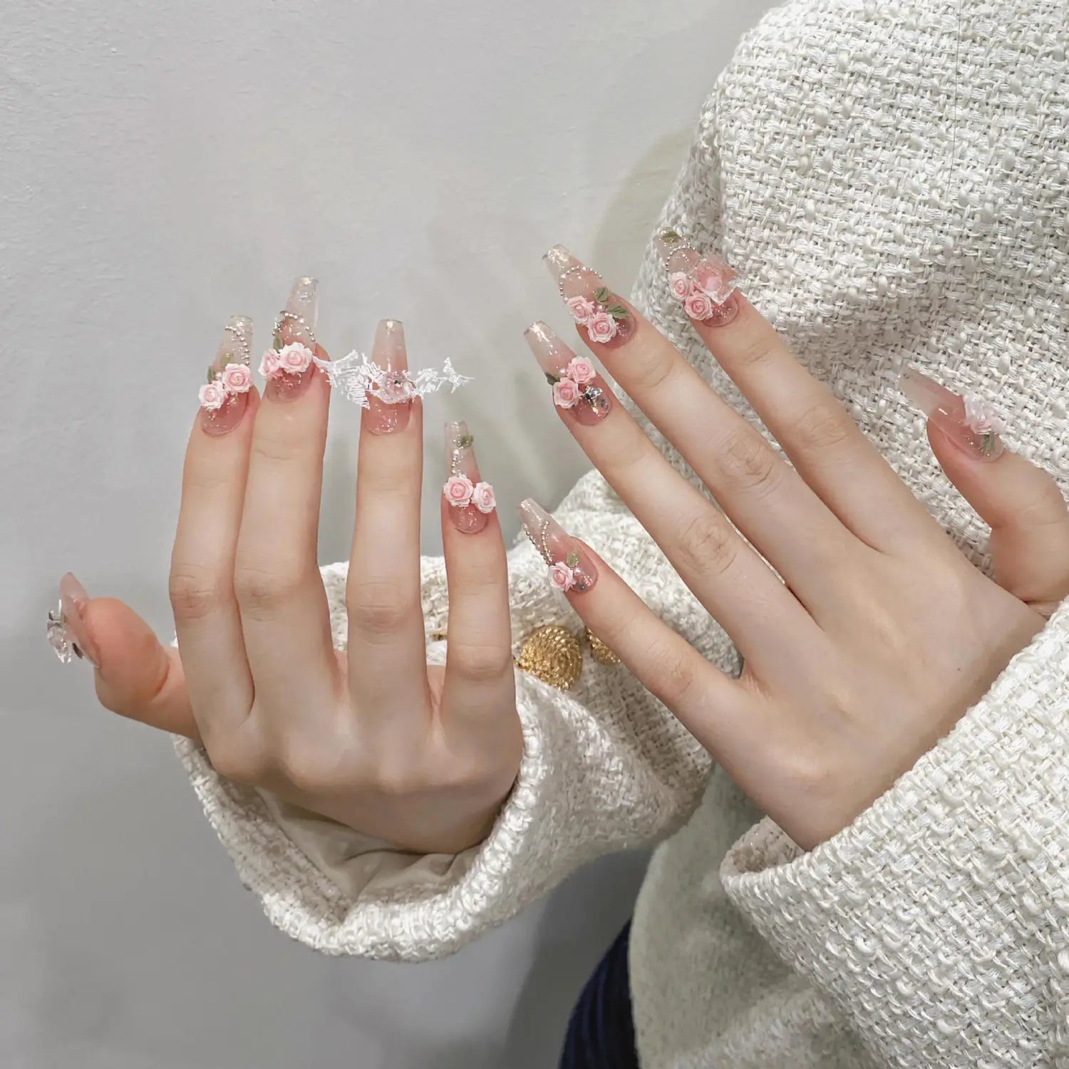 Handmade pink floral almond press on nails featuring long translucent pink acrylic with delicate lace and tiny rose embellishments and glitter.