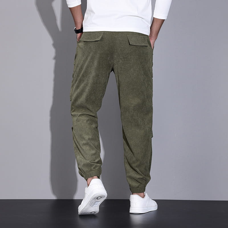 Men corduroy cargo pants in olive green featuring elastic cuffs, multiple pockets, and a loose casual drawstring design.