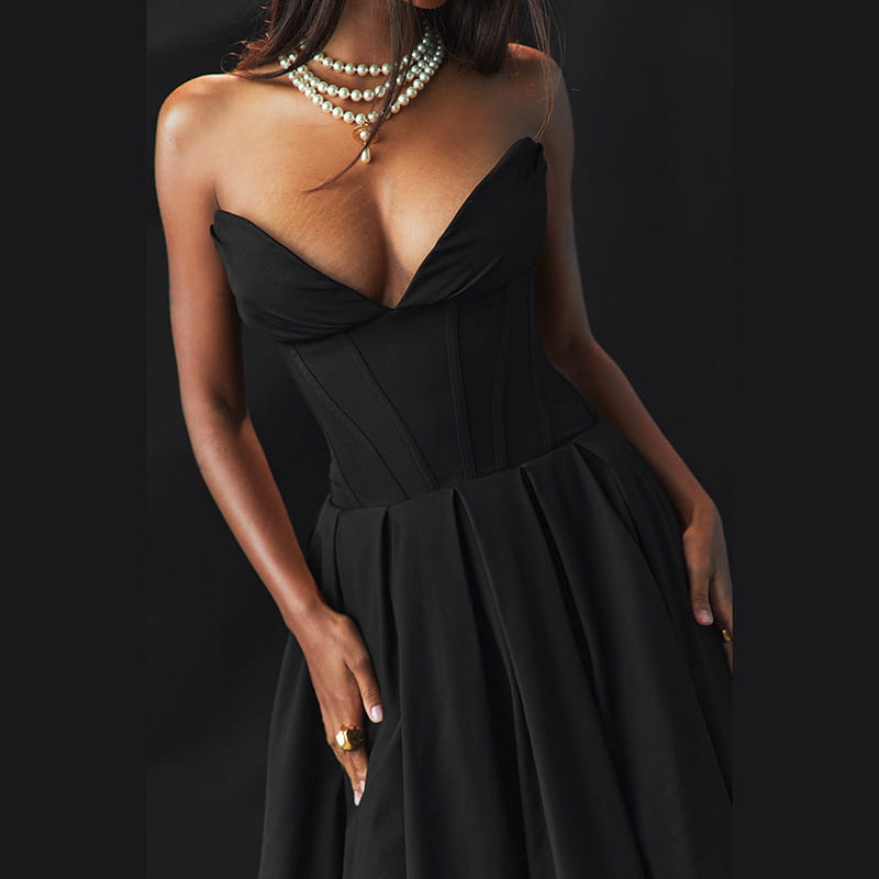 Elegant black strapless flared midi dress featuring a corset-style bodice with a deep v-neckline and a pleated skirt.
