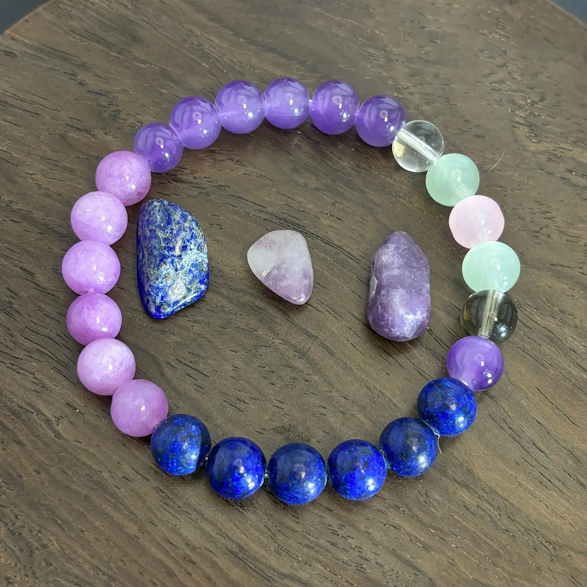 Multicolor gradient fluorite beaded bracelet featuring smooth round purple and blue gemstone beads with a clear crystal accent bead.